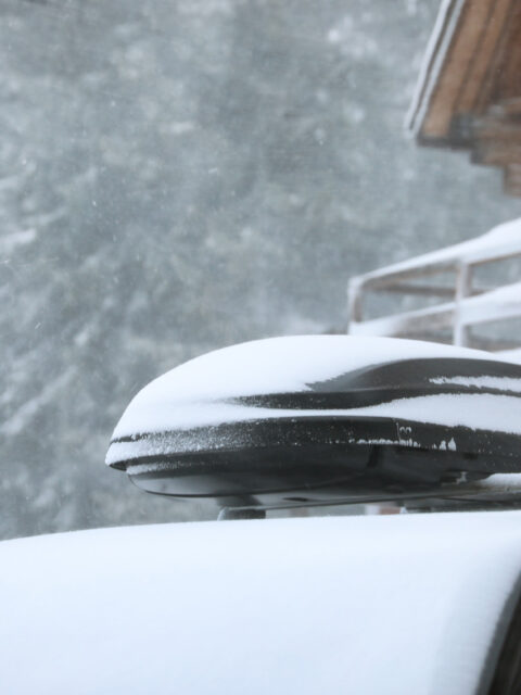 Auto s naloženou batožinou pripravené na zimnú dovolenku v zasneženej krajine.